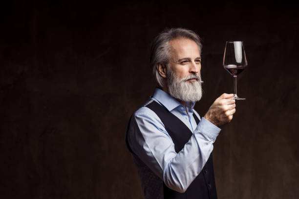 senior sommelier tasting red wine - sniffing glass imagens e fotografias de stock