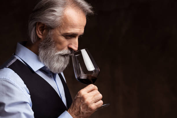 senior sommelier tasting red wine - sniffing glass imagens e fotografias de stock