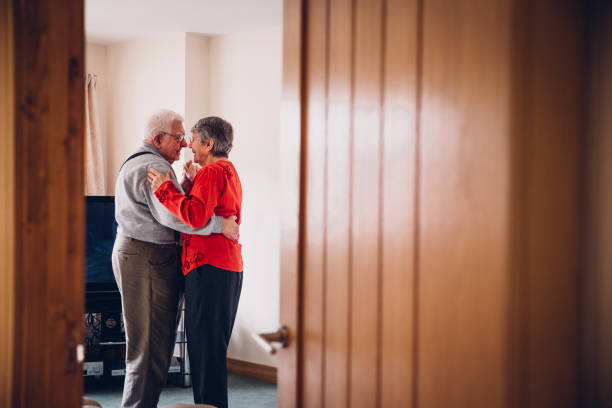 Senior Tenderness as they Dance in their Home Senior couple dance in their Home. flirting photos stock pictures, royalty-free photos & images