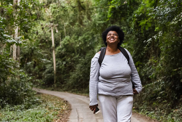 senior turist kvinna promenader i naturpark - woman walking bildbanksfoton och bilder