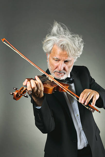 Senior violinist with upset white hairs stock photo