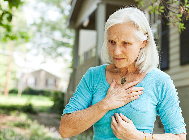 senior with chest pain - borstkas stockfoto's en -beelden