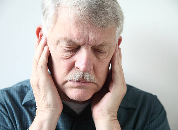 senior with pain in front of ears stock photo