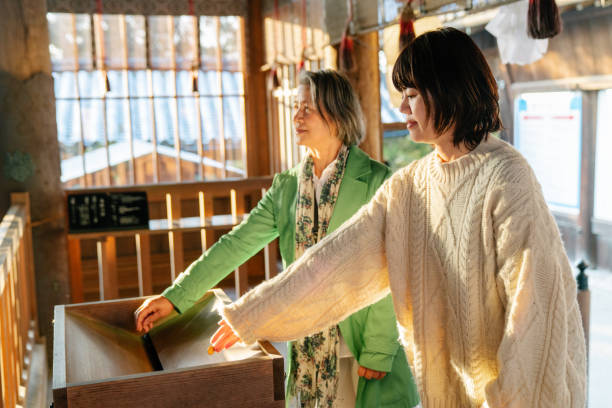 初詣の日本のお寺で祈る先輩女性とその娘 - 初詣 ストックフォトと画像