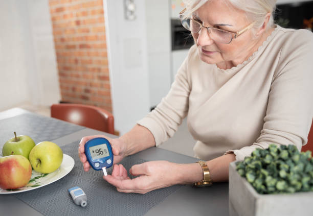 Senior woman checking blood sugar level at home Senior woman with glucometer checking blood sugar level at home. Diabetes, health care concept hyperglycemia stock pictures, royalty-free photos & images