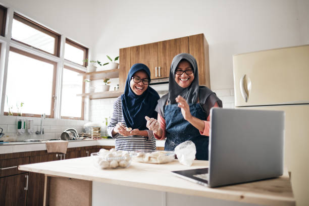 Senior woman doing online communication from home with her daugher Active Senior Cooking Food in The Kitchen cooking class stock pictures, royalty-free photos & images