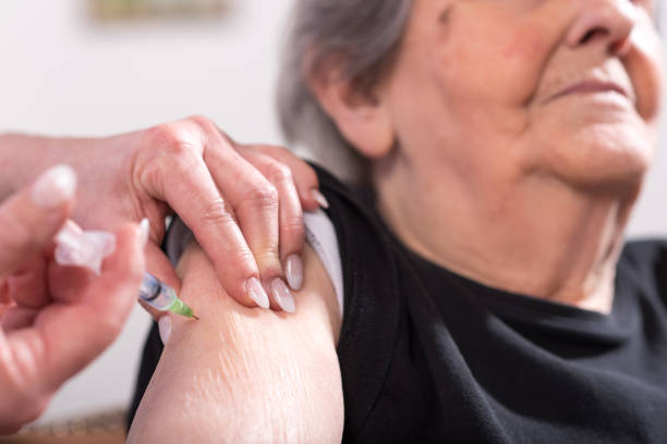 Senior woman getting an injection stock photo