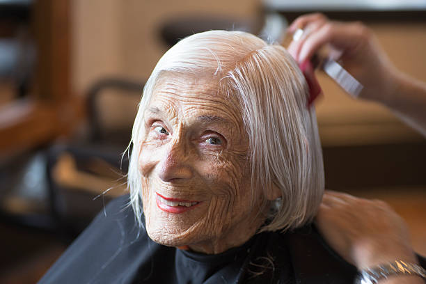 Senior woman happily relaxing at the hairdresser stock photo