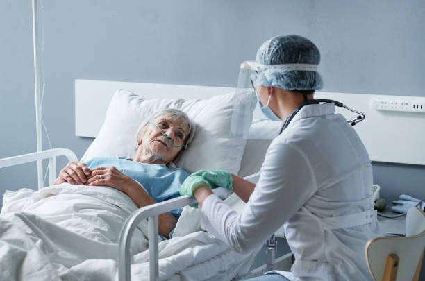 Senior woman lying at hospital during pandemic stock photo