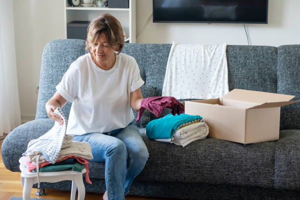 Senior woman preparing and packing donations at home stock photo