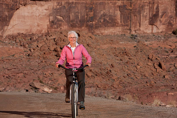 Senior Woman Riding Bike Through the Desert stock photo
