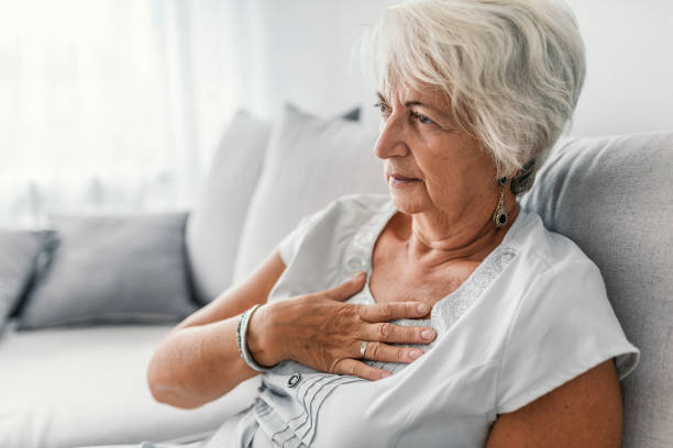 senior vrouw lijden aan symptomen van brandend maagzuur of borst ongemak - borstkas stockfoto's en -beelden