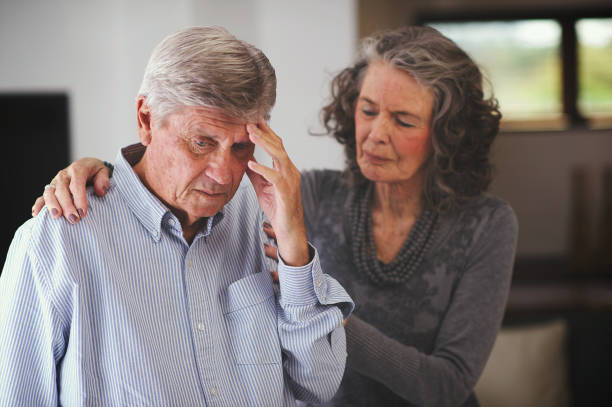 Senior woman supporting a man who has received bad news hand on shoulder stock photo