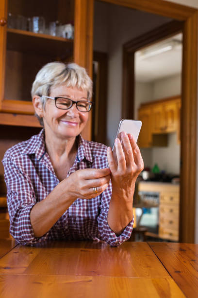 Senior woman using phone. Social distancing, stay at home, lockdown. stock photo