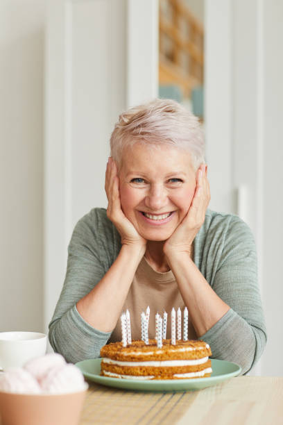 senior woman with cake - grandparents vertical imagens e fotografias de stock