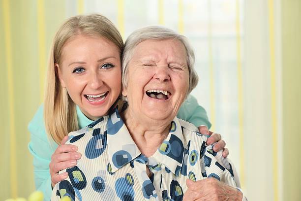 Senior woman with her caregiver. Happy and smiling. stock photo