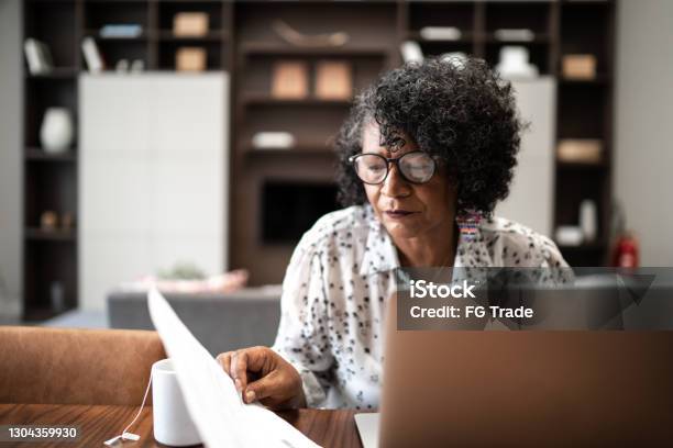 Senior woman working from home or using laptop planning or paying bills