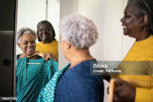Senior women choosing clothes together at home