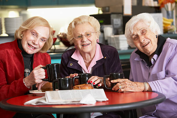 ältere damen trinken tee zusammen - kaffeeklatsch stock-fotos und bilder