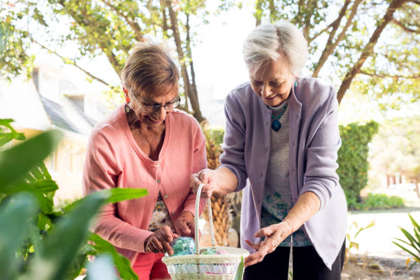 Senior women outdoors with Easter egg basket stock photo