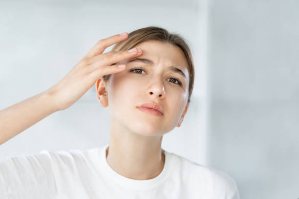 sensitive skin acne problem woman touching face stock photo
