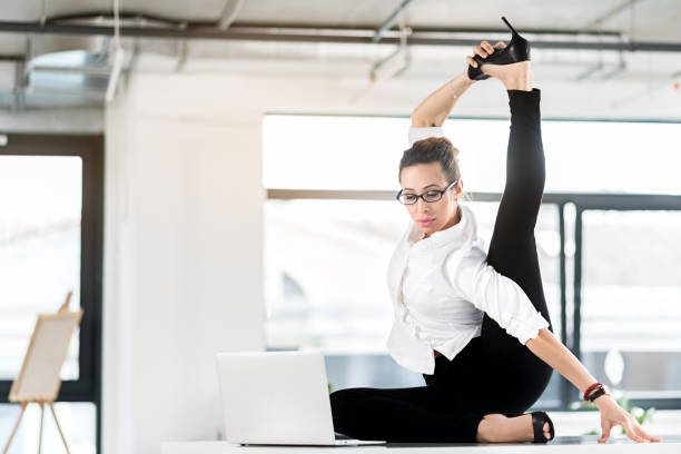 Serene female making gymnastic exercise during job Woman expressing calmness while doing physical jerk. She looking at notebook computer. Rest concept yoga ball work stock pictures, royalty-free photos & images