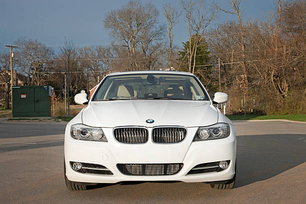 BMW 3 Series "Nashville, USA - March, 8th 2011: A front view of a white 2011 BMW 335i sport sedan in front of some leafless trees and wooded area in Nashville TN." bmw stock pictures, royalty-free photos & images