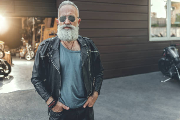 serious bearded old man wearing leather - garagem abrindo imagens e fotografias de stock