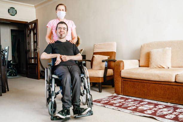 serious disabled young man at home with nurse - blood bar imagens e fotografias de stock