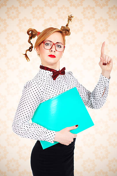 serious female teacher wearing glasses posing with green folder - ugly teac...