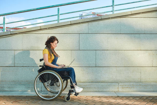serious girl walking with wheelchair - wheelchair street imagens e fotografias de stock