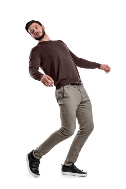 A serious looking bearded man in casual clothes stands in a half-turned view as if almost falling behind. A serious looking bearded man in casual clothes stands in a half-turned view as if almost falling behind. Keeping balance. Falling back. Losing your footing. bending stock pictures, royalty-free photos & images