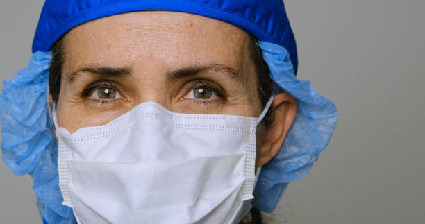 trabajadora de la salud seria, sobrecargada de trabajo - nurse face fotografías e imágenes de stock