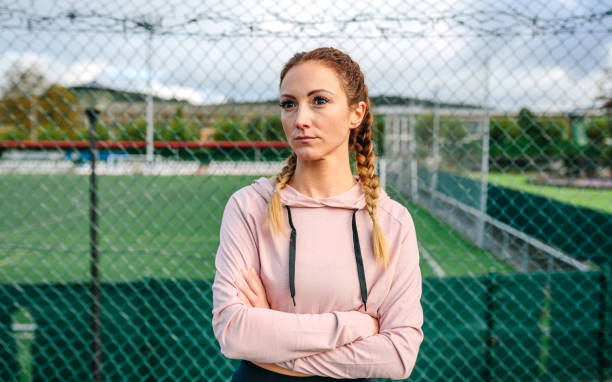 Serious sportswoman with boxer braids posing with crossed arms stock photo