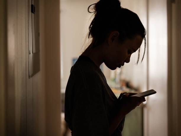 allvarlig kvinna tittar på sin telefon hemma stressad. - trakasserier bildbanksfoton och bilder