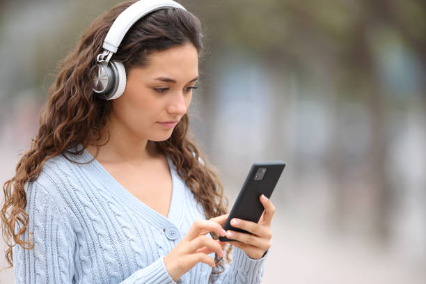 Serious woman with headphones listening to music stock photo