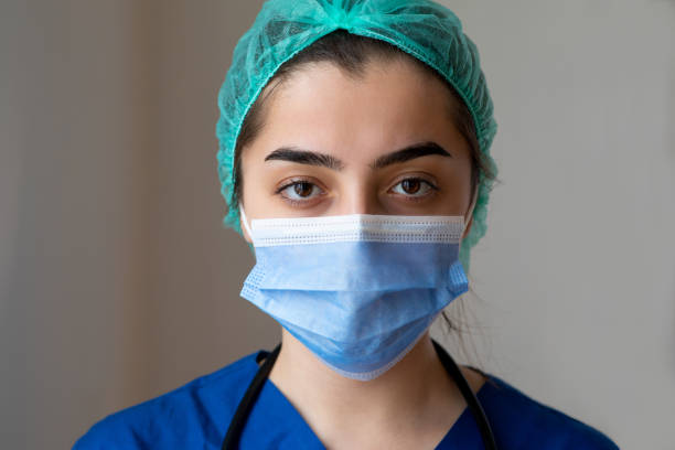 trabajadora sanitaria joven grave - nurse face fotografías e imágenes de stock