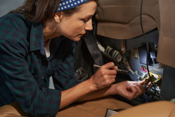 Seriously brunette woman mechanic is repairing aircraft stock photo