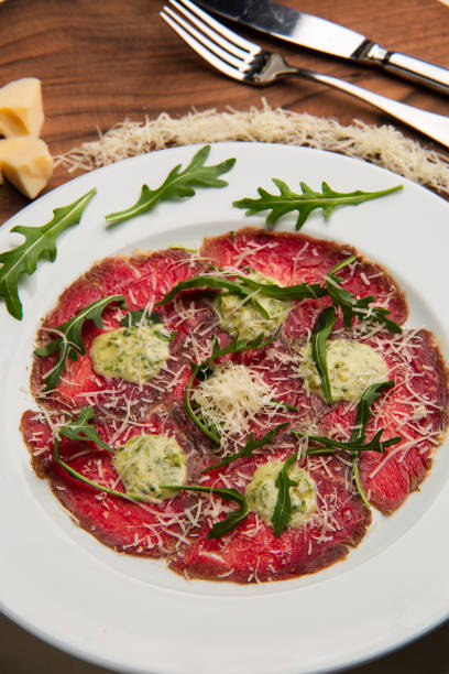 Served plate with carpaccio with arugula on a white plate in a restaurant. stock photo
