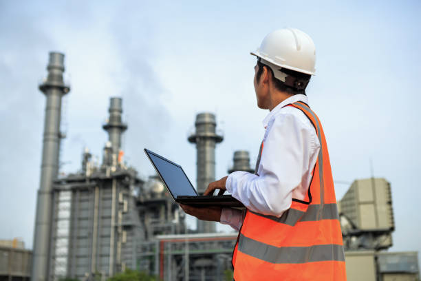 Service engineer is working at electric power plant with laptop Service engineer is working at electric power plant with laptop nuclear power station stock pictures, royalty-free photos & images
