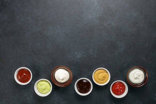 Set of different sauces Set of different sauces - ketchup, mayonnaise, barbecue,  teriyaki, mustard, pesto, adzhika on dark background. Top view. Flat lay. Copy space condiment stock pictures, royalty-free photos & images