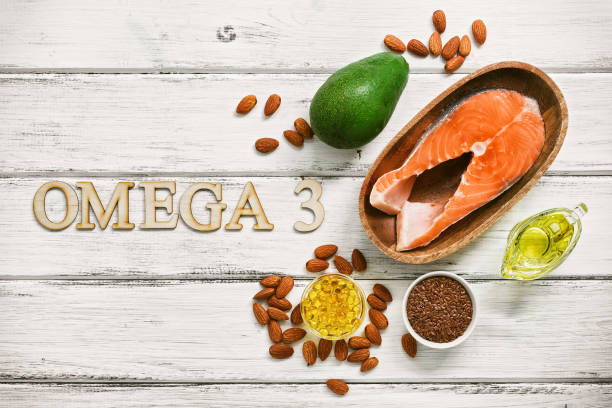 en uppsättning livsmedel med hög halt av omega-3 fettsyror på en vit trä bakgrund. hälsosam kost koncept. lax, avokado, linfrön, fiskolja kapslar, olja, mandel. utsikt från ovan. - omega 3 bildbanksfoton och bilder