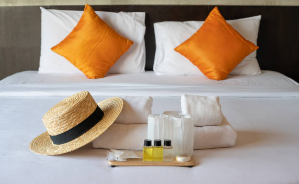 Set of hotel amenities (such as towels, shampoo, soap etc.) on the bed. stock photo