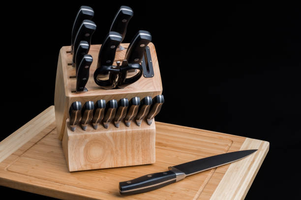 juego de cuchillos de cocina en una tabla de cortar de madera - knife fotografías e imágenes de stock