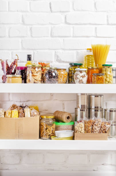 Set of long storage term foods on pantry shelf prepared for disaster emergency conditions on brick wall background Set of long storage term foods on pantry shelf prepared for disaster emergency conditions on brick wall background pantry stock pictures, royalty-free photos & images