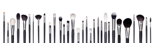 Set of make-up brushes lined up in alternating pattern. Isolated on white stock photo