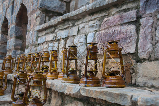 A set of old lanterns placed against a stone wall stock photo