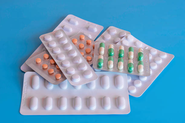 Seven blisters of generic tablets on blue background.Pills in packages.Various medication.Pharmaceutical industry.Overprescribing of medicines in UK stock photo