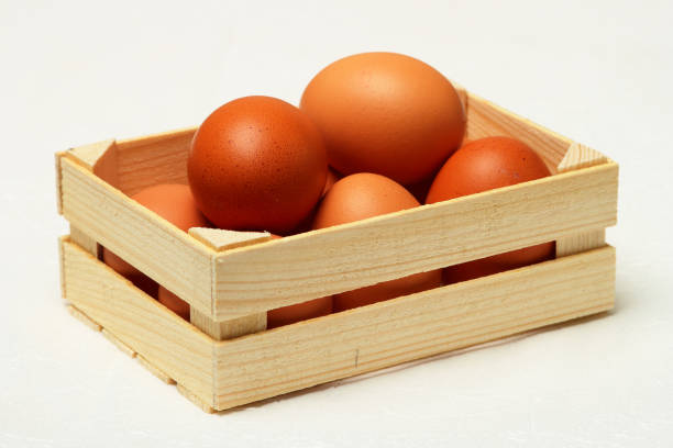 Several chicken eggs in wooden box. stock photo