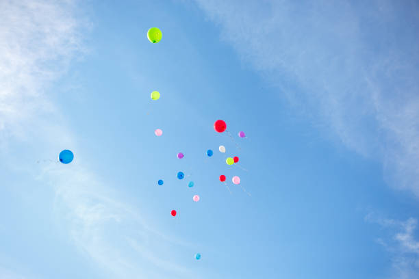 A several coloured air balloons are flying into the blue sky stock photo
